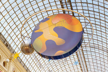 Moscow, Russia - November 21, 2019: Bright planet layout under glass roof of GUM State Department Store. New Year installations at GUM interiors on Red square in Moscowのeditorial素材