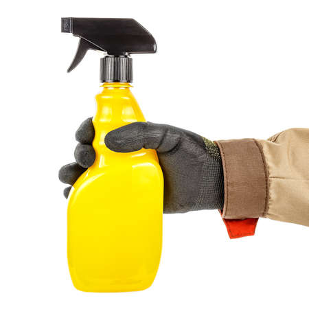 Bright yellow plastic spray bottle in male hand in black protective glove and brown uniform isolated on white backgroundの写真素材