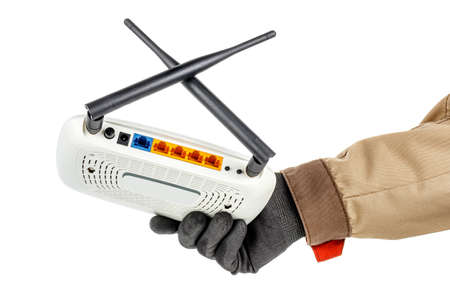 Male hand in black protective glove and brown uniform holding wireless wi-fi router with colored...