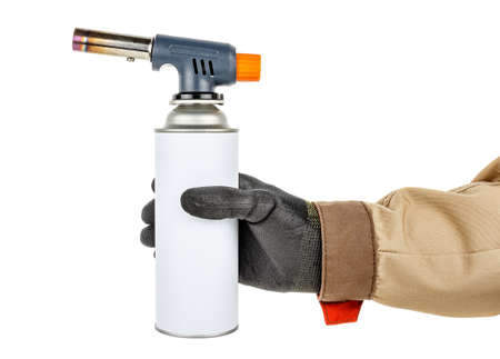 Male hand in black protective glove and brown uniform holding large welding butane torch with white...