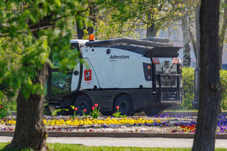 Moscow, Russia - May 01, 2019: Small sweepers truck against trees and flower beds in city park at sunny spring morningのeditorial素材