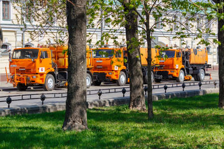 Moscow, Russia - May 01, 2019: Three large orange sprinkler trucks with plastic water tanks parked on Moscow street in sunny spring morningのeditorial素材