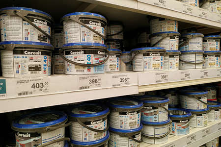 Moscow, Russia - August 17, 2019: Plastic jars with grout for ceramic tiles on the rack in a building materials storeのeditorial素材