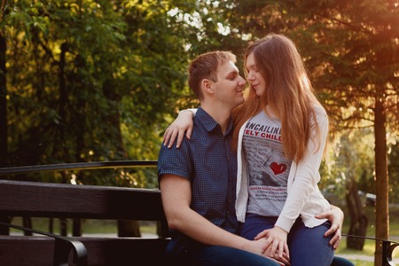 lovely young couple sitting on seat benchの写真素材