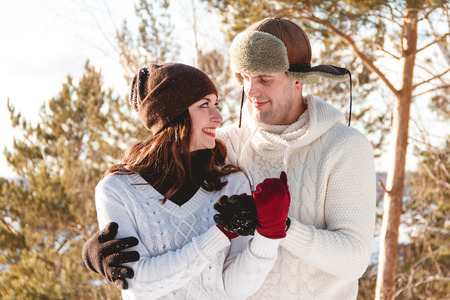 A beautiful girl and boy walking husky dog in winter forestの写真素材