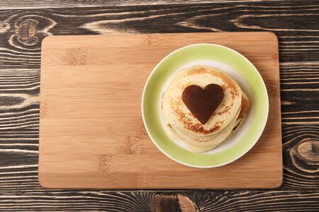 stack of pancakes with on brown wooden board, heart-shaped, Shrove Tuesday, Valentines Dayの写真素材