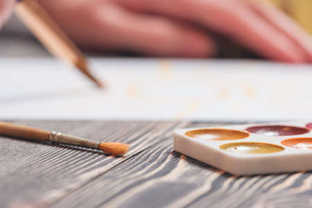 paint brushes and palette on wooden backgroundの写真素材