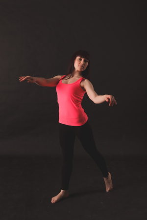 Portrait Of Young Beautiful Woman Dancing In sportswear over black backroundの写真素材