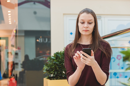 Woman using mobile phone inside the buildingの写真素材