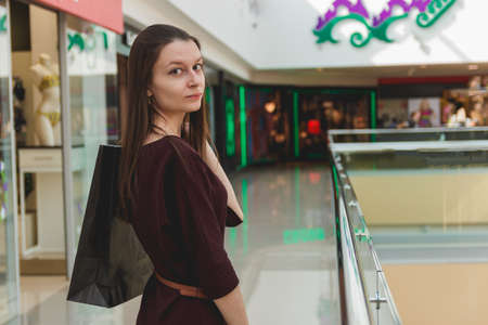 Attractive cute girl with the shopping bags in her hand inside the mallの写真素材