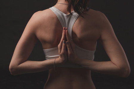 Beautiful sporty yogi girl practices yoga asana over black backgroundの写真素材