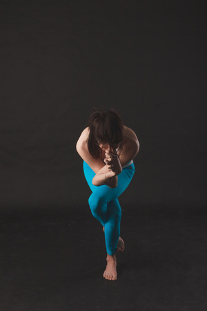 Beautiful sporty yogi girl practices yoga asana over black backgroundの写真素材