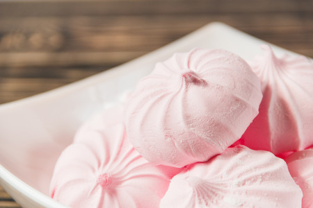 Fresh Pink Marshmallows - Zephyr in White Plate on Wooden Background. Sweet Dessert Conceptの写真素材