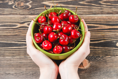 Red Cherries in the Green Cup on Wooden Table, Fruits, Berries Healthy Food Conceptの写真素材