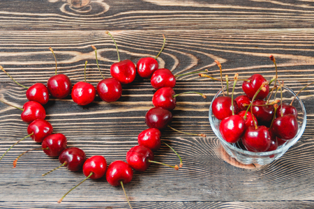Red Cherries in the Green Cup on Wooden Table, Fruits, Berries Healthy Food Conceptの写真素材
