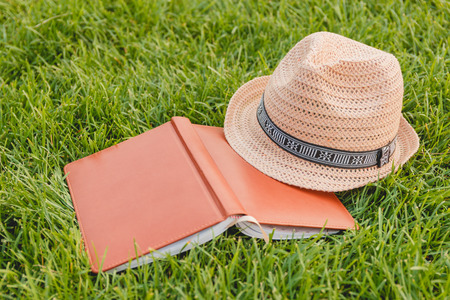 Hat, Book, Notebook on a Green Grassの写真素材