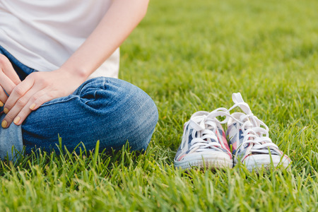 Youth Sneakers on Grass During Sunny Serene Summer Dayの写真素材