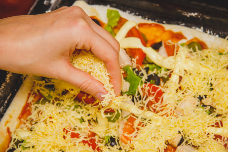 women hand prepare homemade rectangular pizza, ingredients close upの写真素材