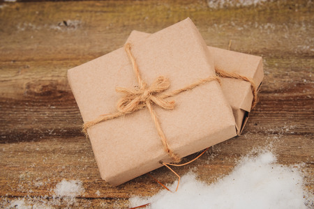 Classy Christmas gifts box presents on brown wooden background. Christmas and Happy New Year concept.の写真素材