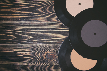 old vinyl record on the wooden table, selective focus and toned image