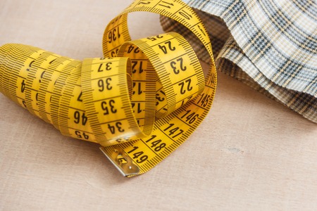 Curved measuring tape. Closeup view of yellow measuring tape.
