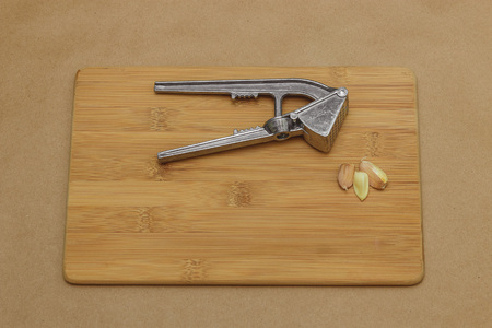 garlic and garlic press on cutting board with copyspace.