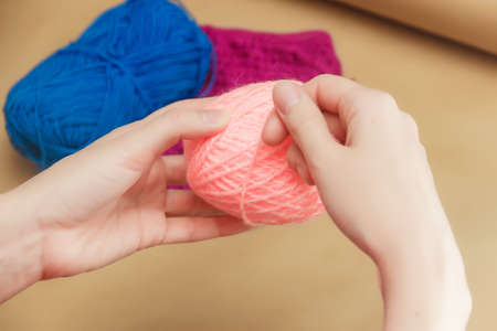 Close up of the hands of an young woman knitting.
