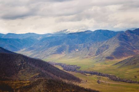 landscape with mountains, forest, meadow in front. beautiful sceneryの写真素材