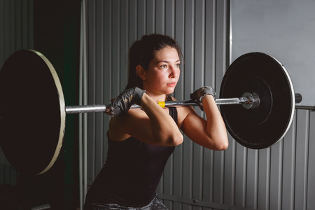 Strong woman lifting barbell as a part of crossfit exercise routineの写真素材