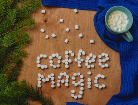 Christmas background with fir, words coffee magic, scarf, cup of coffeeの写真素材