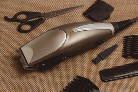 Stylish Professional Hair Clippers, accessories on brown background