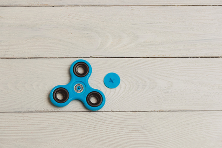 Blue fidget spinner stress relieving toy on wooden backgroundの写真素材