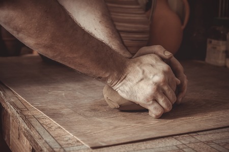 Adult male potter master mashing the clayの写真素材