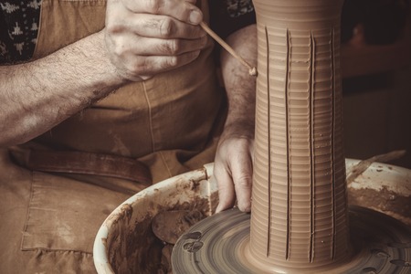 elderly man making pot using pottery wheel in studioの写真素材