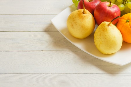 Healthy fruit mix on the wooden kitchen table with copy spaceの写真素材