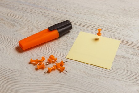 Stationary, Blank Yellow Sticker, Orange Pushpins, Marker on White Wooden Board. Memo, Reminder.の写真素材