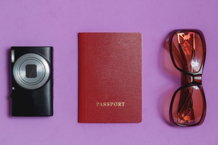 Passport, Sunglasses, Photo Camera on lilac Background. Top View Travel Concept.の写真素材