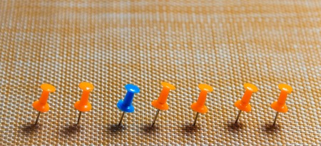 Stationary, Blue Pushpin in Row with Orange, Concept for Difference, Individuality, Leadership. Copy Space. Banner.の写真素材