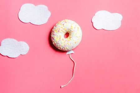 Donut on Pink, Creative Food Minimalism, Donut in Shape of Balloon in Sky with Clouds, Top View with Copy Space, Tonedの写真素材