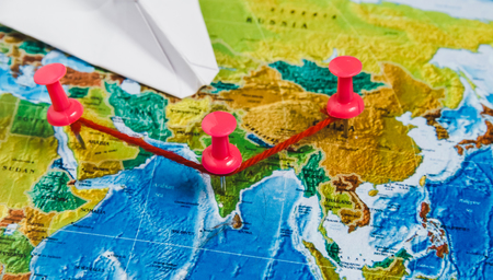 Travel Destination Points on World Map Indicated with Colorful Thumbtacks, Red Rope and Shallow Depth of Fieldの写真素材