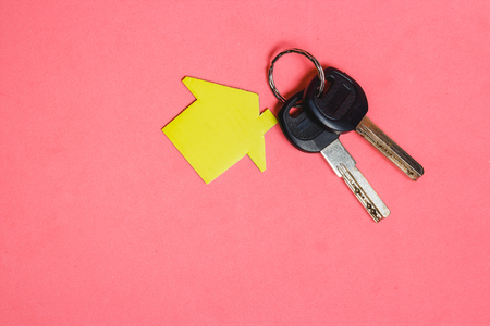 Symbol of House with Two Silver Keys on Pink Background. Concept of Minimalism with Copyspaceの写真素材