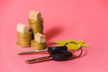 Stacks of Coins with Miniature House and House Keys as Mortgage and Investment Concept.の写真素材