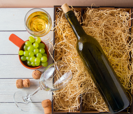 wine bottle, corks, grapes in wooden box. top view.の写真素材