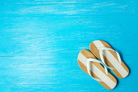 Frame elegant female slippers on blue wooden background, copyspace for text, summer vacation.の写真素材