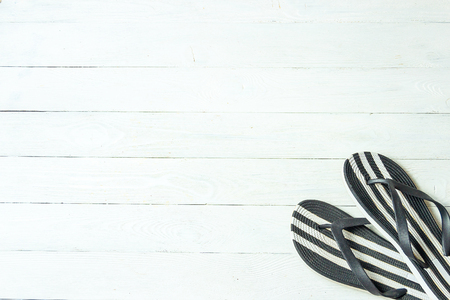 Frame elegant female slippers on white wooden background, copyspace for text, summer vacation.の写真素材