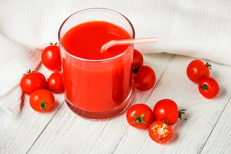 Tomato juice in glasses on white wooden table.の写真素材