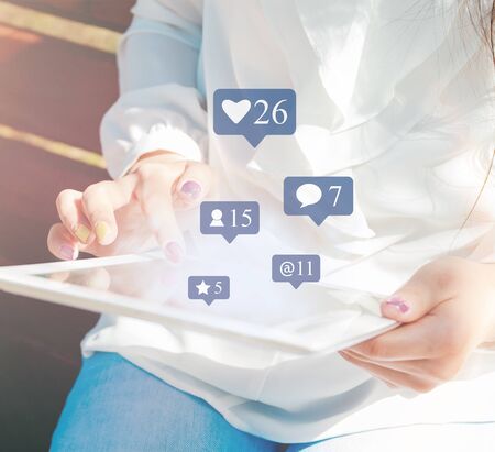 blogger holds tablet with flying social media icons of likes, comments, folowwers, stars. Illustration of network influence.の写真素材