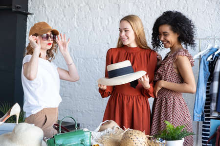 Happy women at swap party. Choose casual clothes, shoes, hats, bags, jewellery. Idea of exchange...