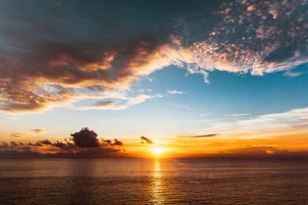 Amazing colorful red sunset at tropical islands. Beautiful cloudscape over the sea. Silhouettes in...