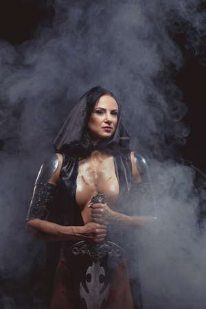 Sexy Fantasy Warrior Woman with big sword on black with smokeの写真素材